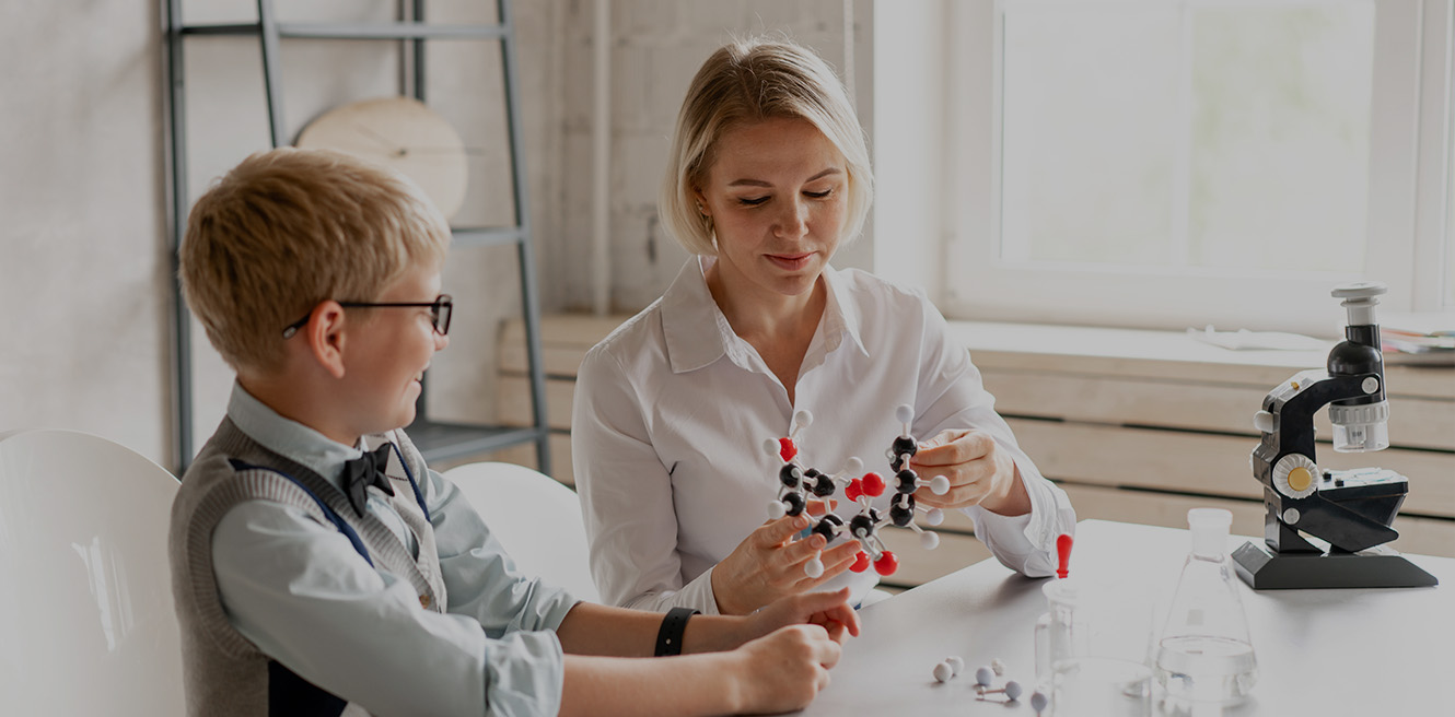 Female science tutor in Queens studying chemistry with student